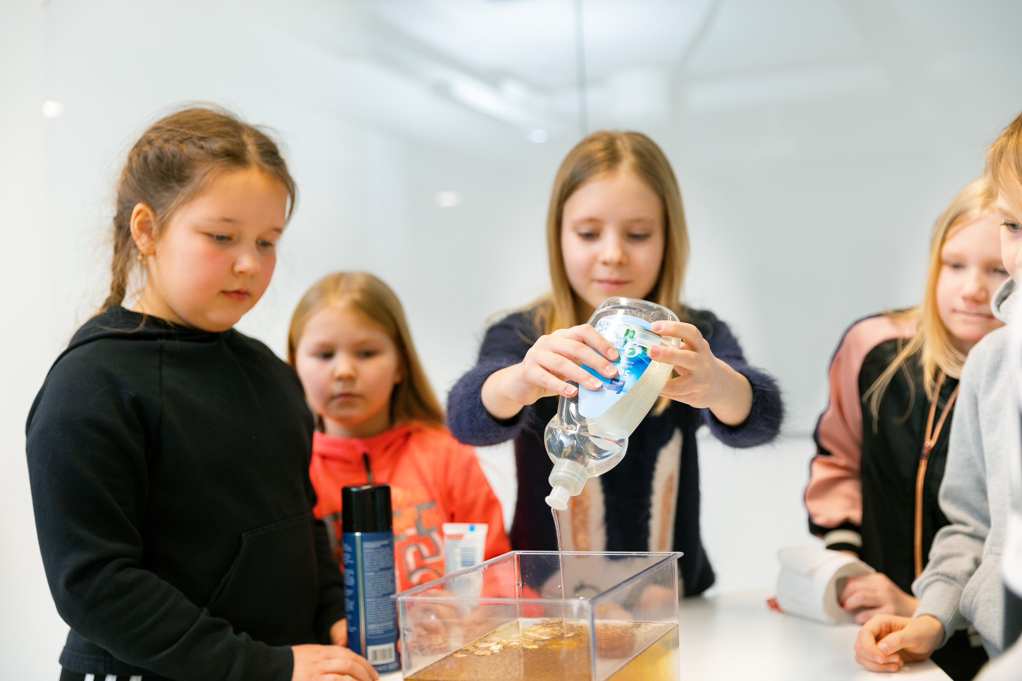 Koululaiset tutkivat astianpesuaineen kemiallista käyttäytymistä.